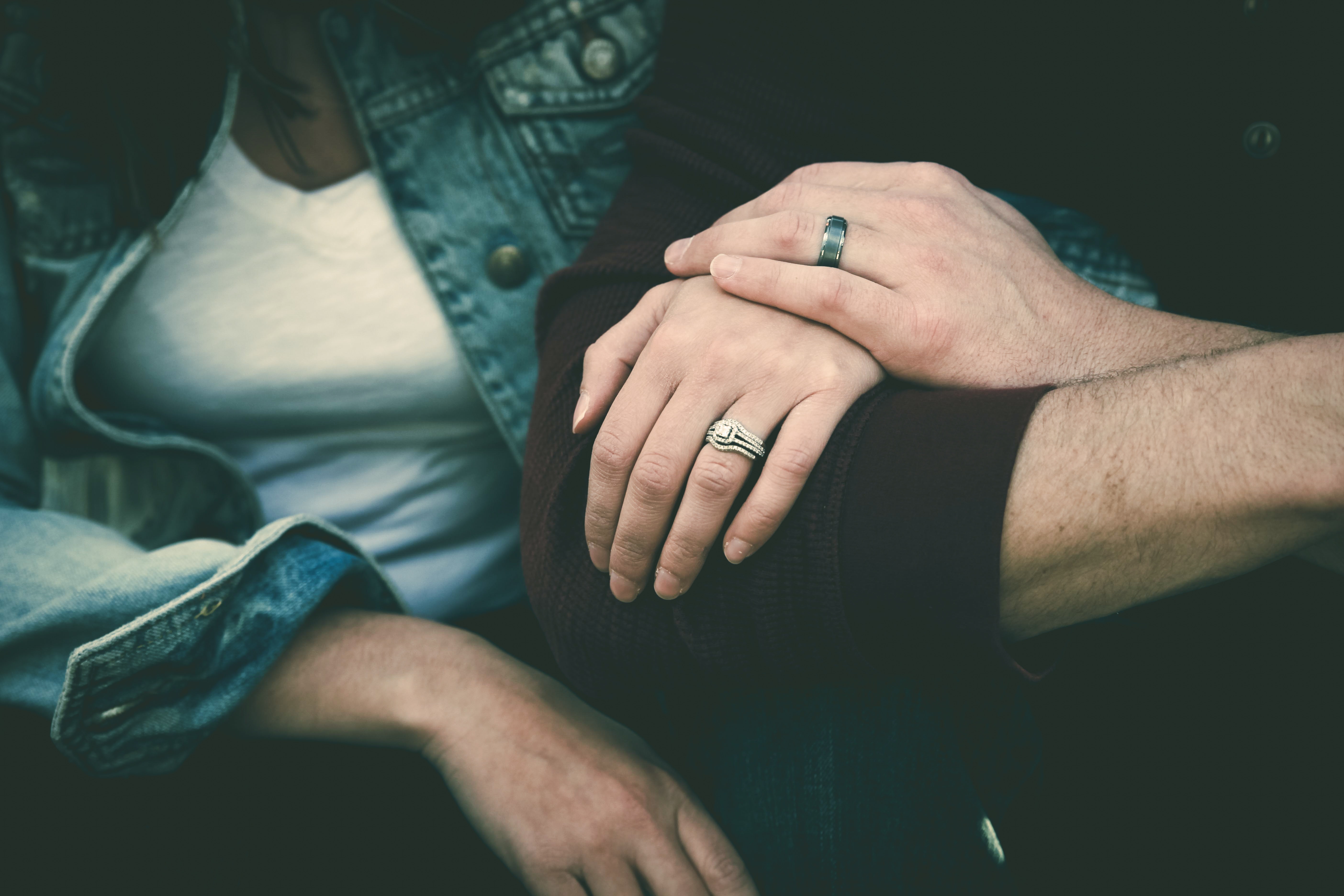 Close-up of a couple holding hands and wearing wedding rings